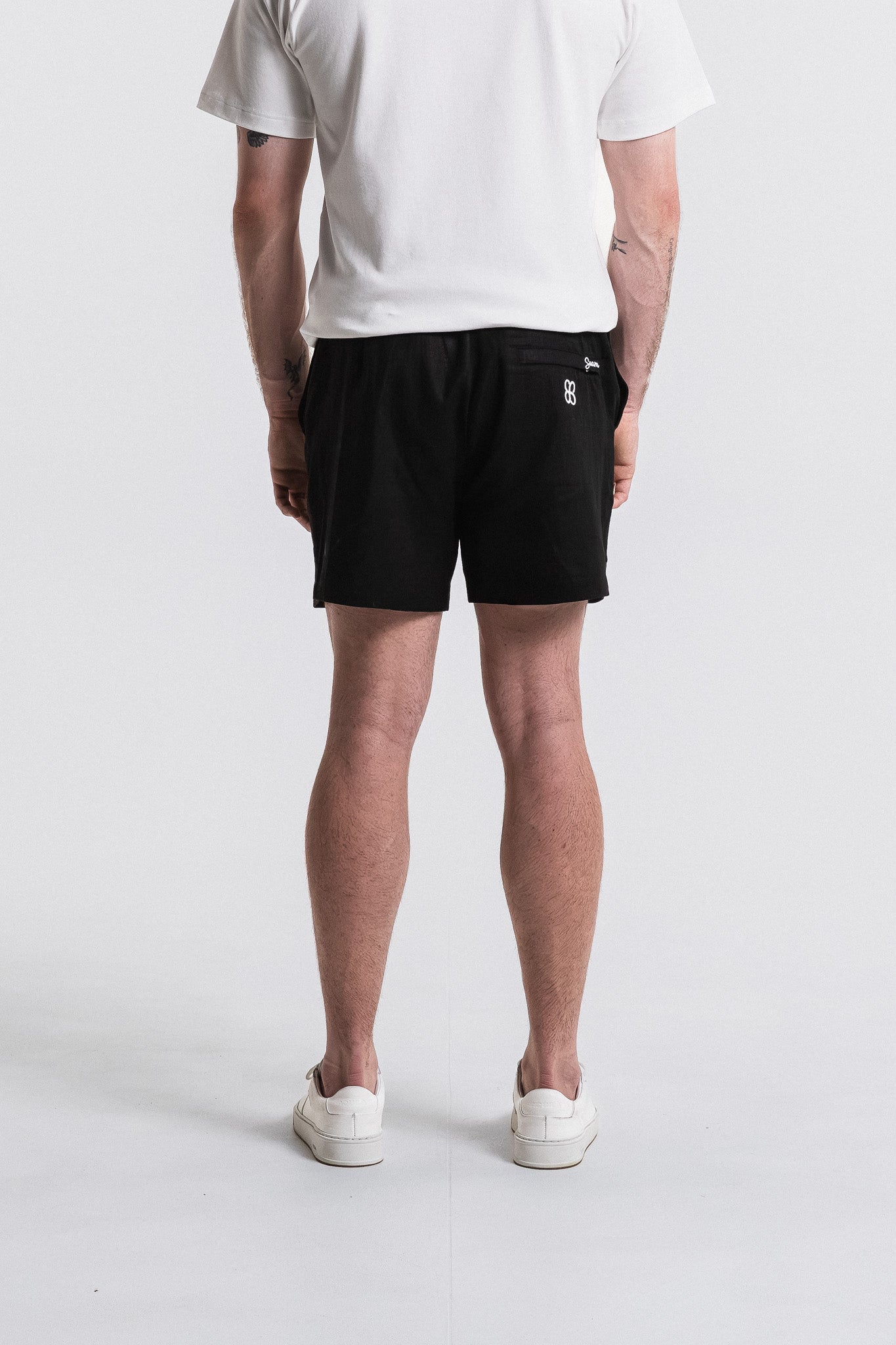 SEAM Side Tab Linen Short in Black, close-up of embroidered Seam logo at pocket