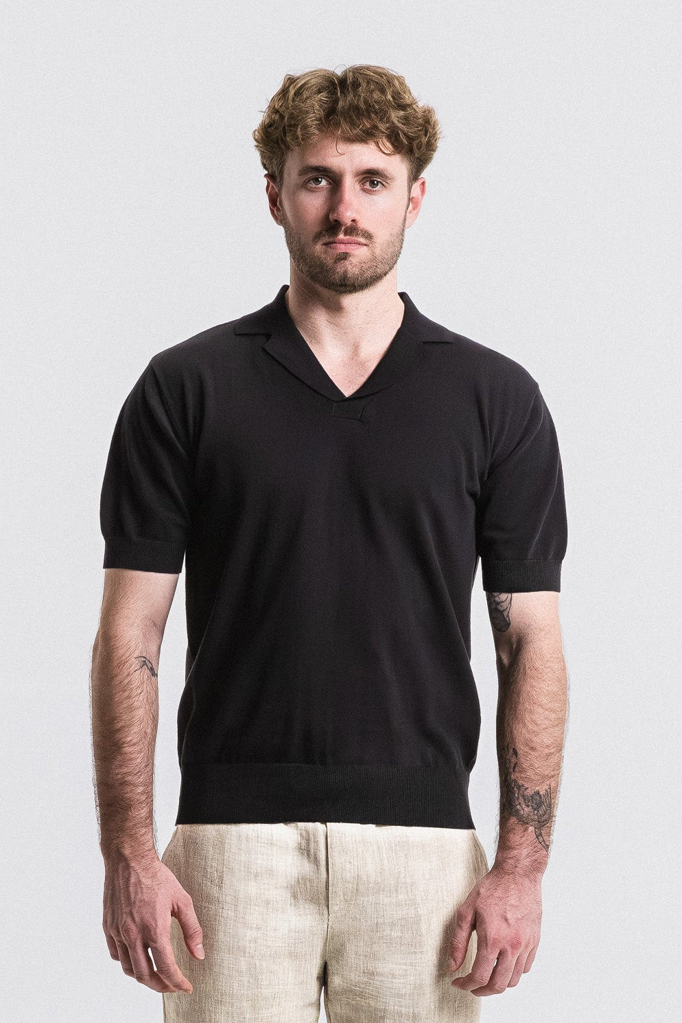 SEAM Cotton Knit Open Neck Polo in Black, full outfit view with beige pants