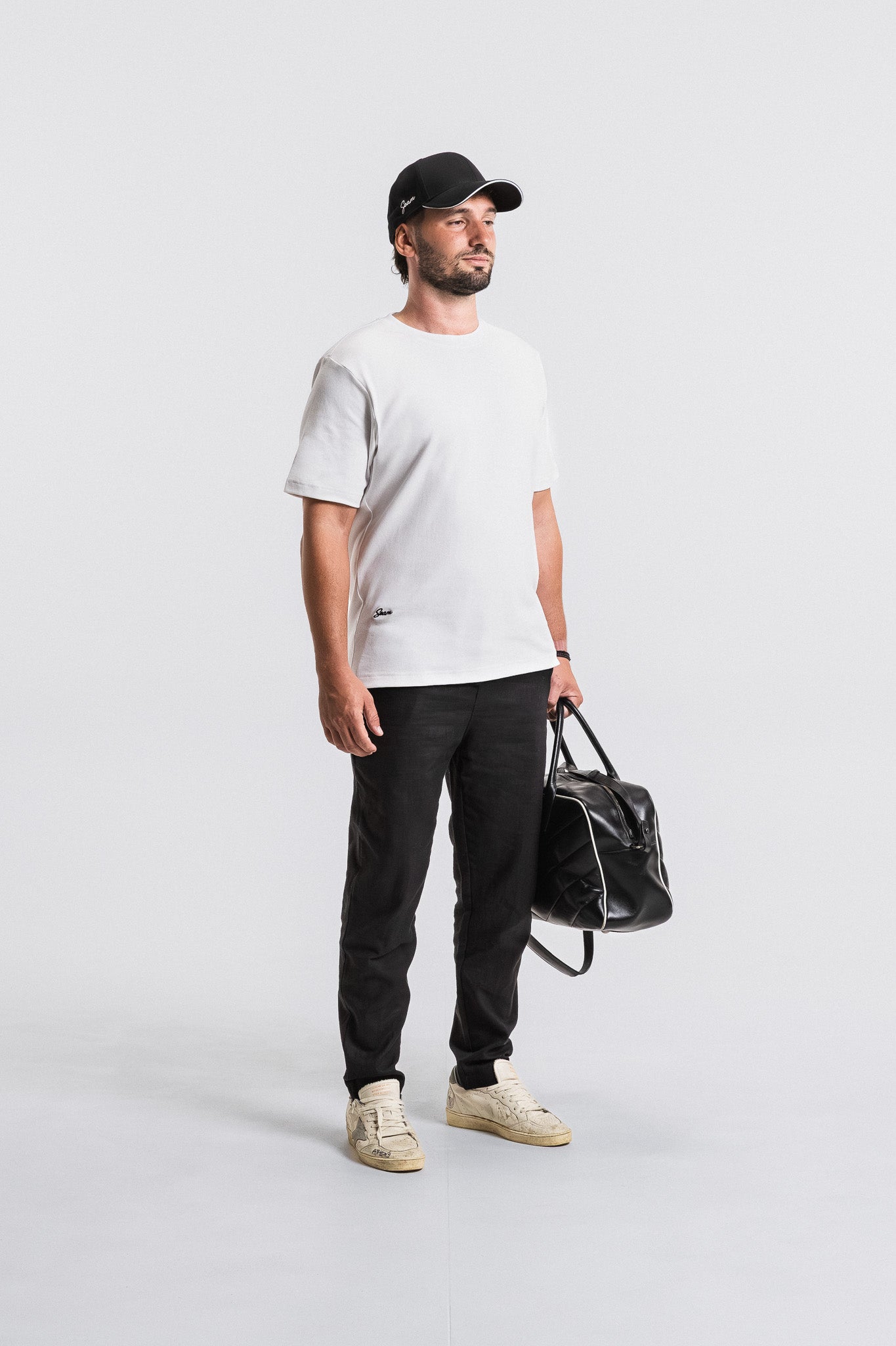 SEAM Relaxed Fit Cotton T-Shirt in White, model styled with black pants and cap