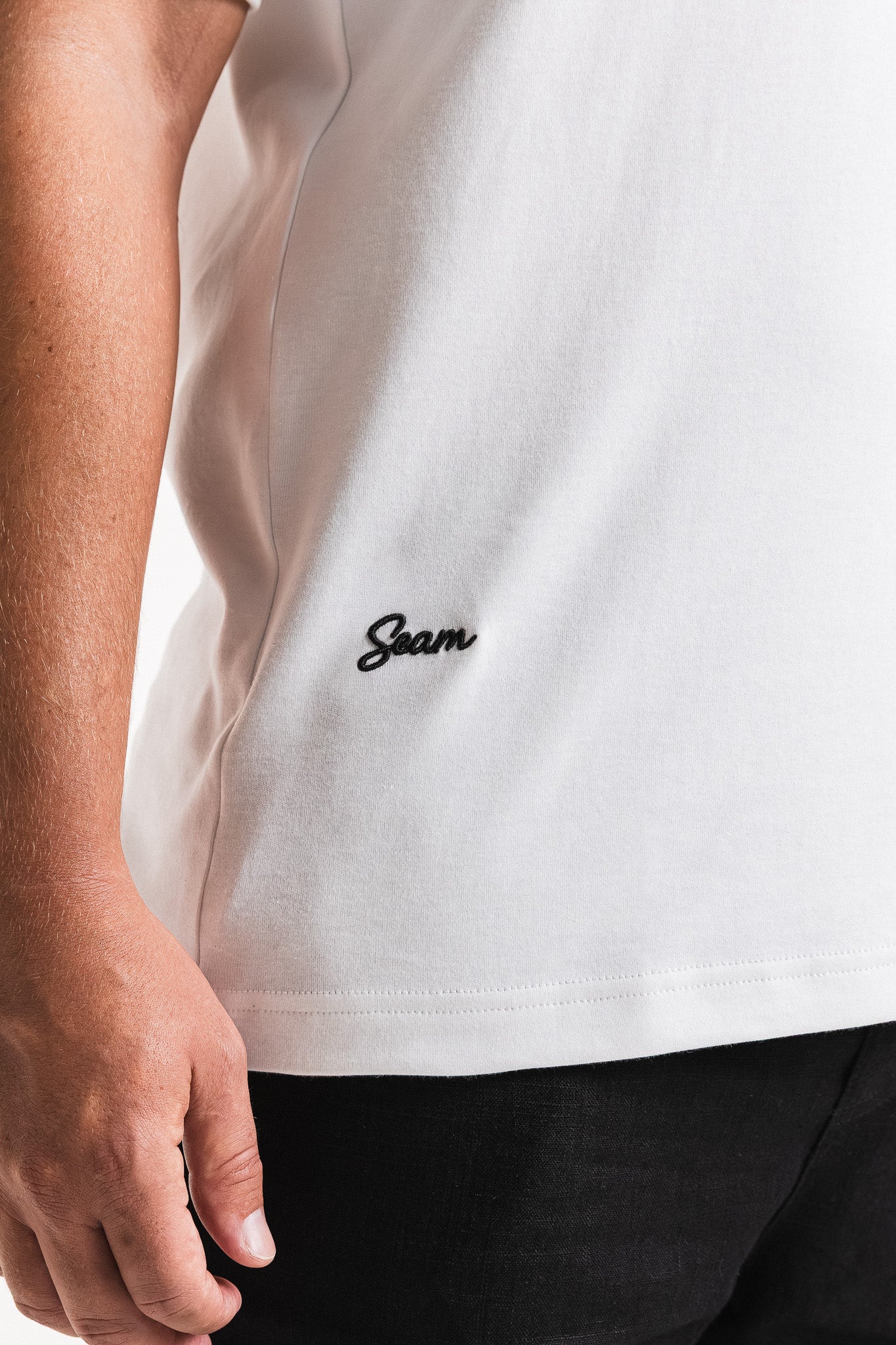 SEAM Relaxed Fit Cotton T-Shirt in White, close-up of embroidered Seam monogram at chest