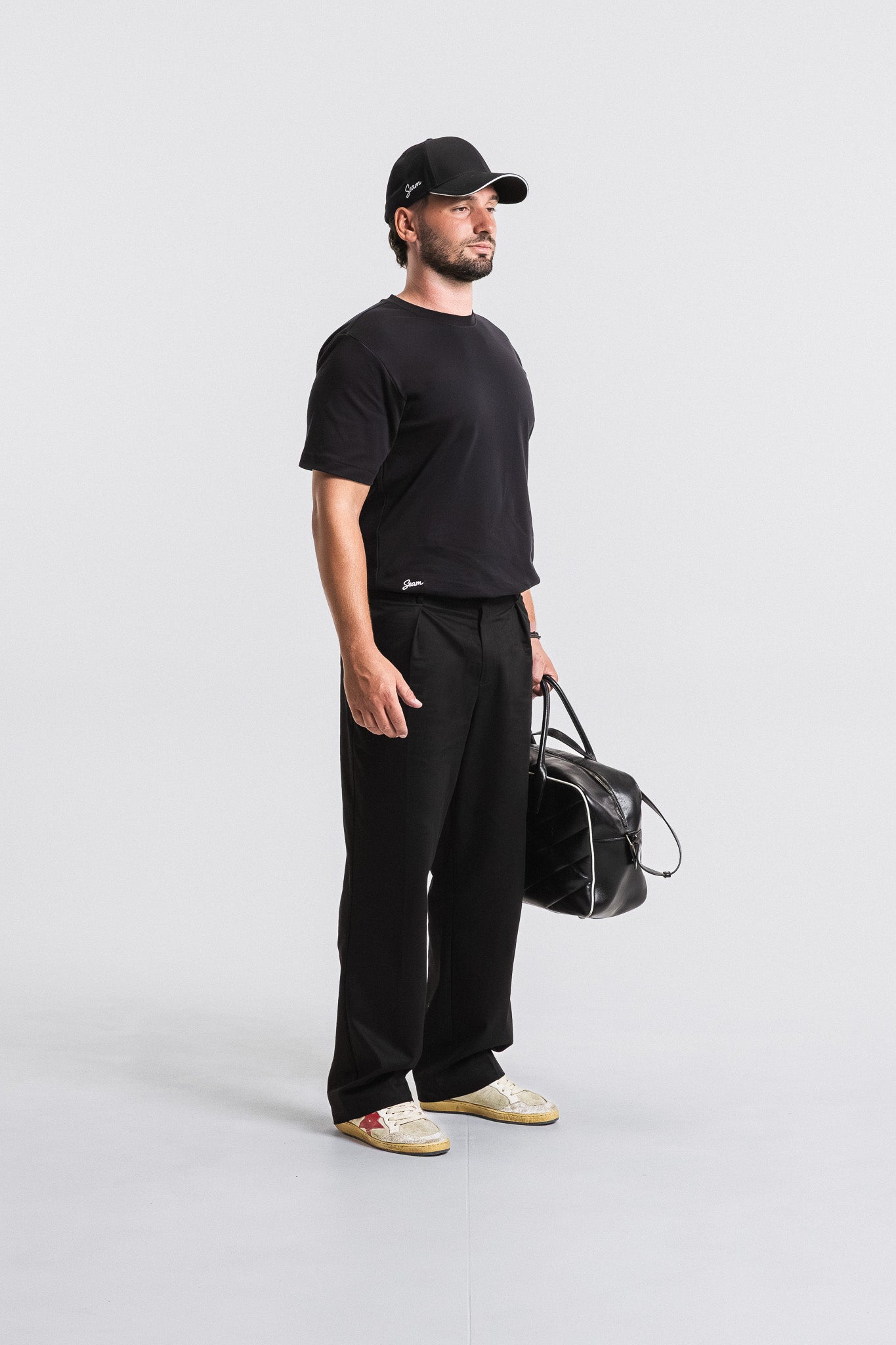SEAM Relaxed Fit Cotton T-Shirt in Black, model styled with black pants and cap