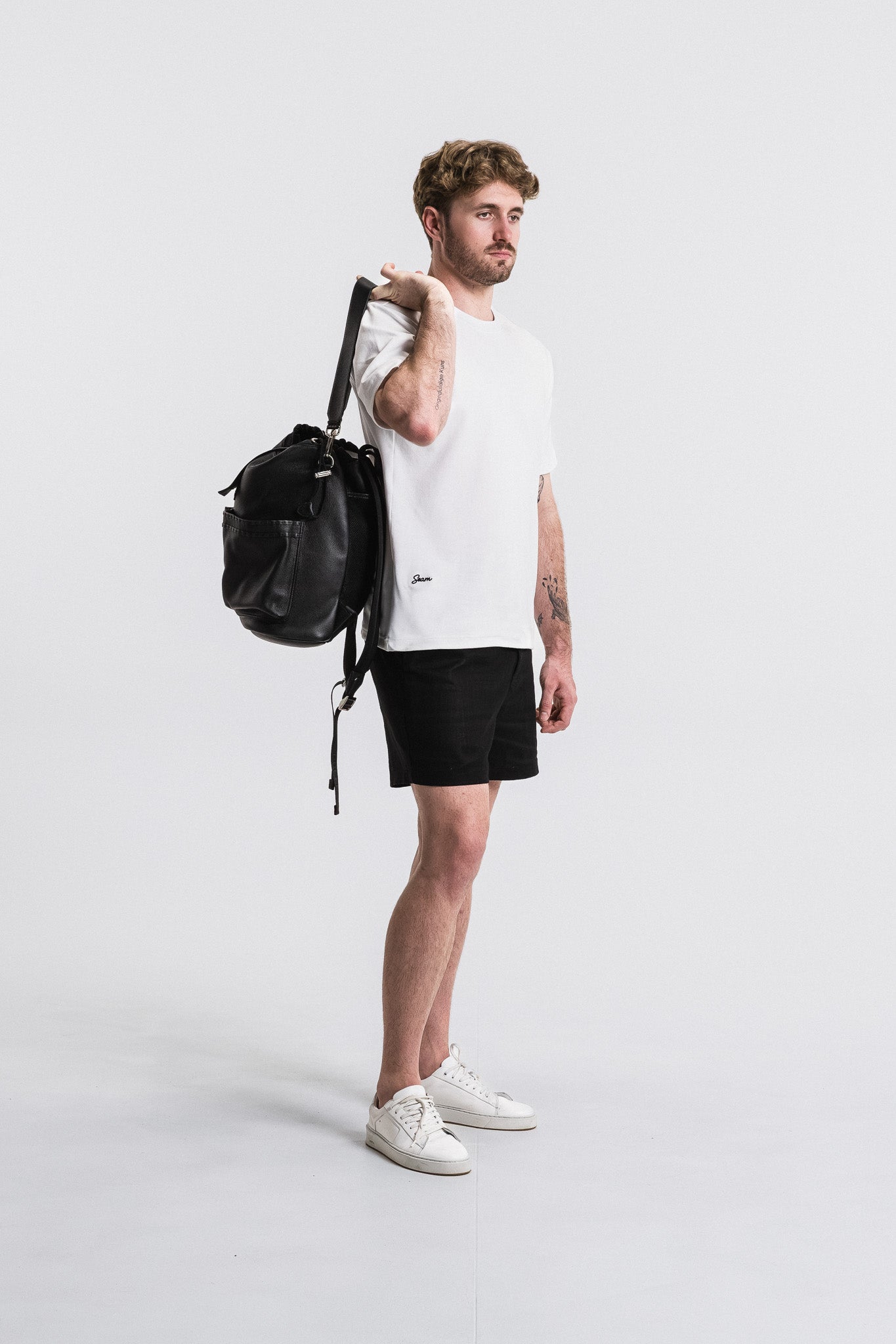 SEAM Side Tab Linen Short in Black, model holding bag in styled outfit